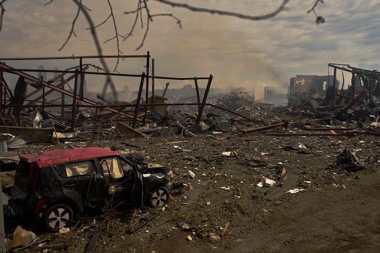 Destroyed vehicles and debris are scattered the day after a Russian attack struck a warehouse, followed by an explosion, in the village of Myla, outskirts of Kyiv, Sunday, Aug. 30, 2026.