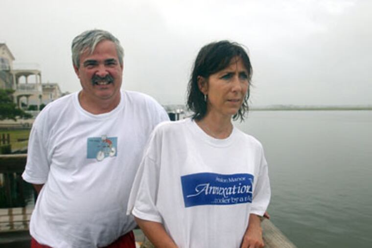 This file photo shows Dr. Thomas McFarland with his wife, Joanne, on the pier at their home in Avalon, N.J. McFarland, a suburban Philadelphia dentist, was charged last year with dumping medical waste that fouled beaches in Avalon. (Sarah J. Glover / Staff Photographer)