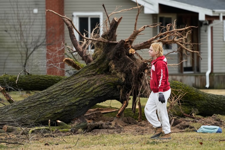 A volunteer works to clear debris a day after a storm whipped up a tornado through the area, in Union City Mich., Saturday, March 7, 2026.