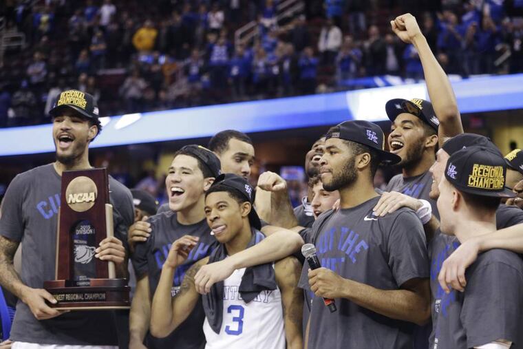 Kentucky players celebrate with the regional championship trophy after a 68-66 win over Notre Dame in a college basketball game in the NCAA men's tournament regional finals, Saturday, March 28, 2015, in Cleveland. (AP Photo/Tony Dejak)