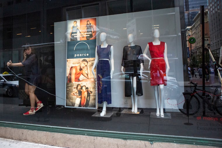 Allie Pearce speaks on the phone while vacuuming around her new window display featuring her clothing line on 13th between Market and Chestnut streets at the Macy's in Center City, Philadelphia on Tuesday, July 02, 2019. Pearce creates gender-inclusive clothing.