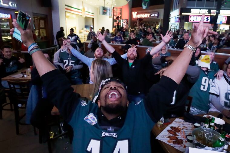 Eagles fans including Anthony Willis of Trenton, N.J. (foreground) celebrate an Eagle touchdown, while watching the game, at XFINITY Live! Philadelphia in South Phila., Pa. on December 29, 2019. The Eagles defeated the Giants 34-17.