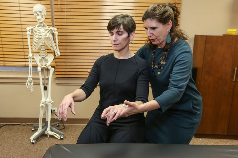 Ariel Weiss teaches the Alexander Technique, a way of thinking about body mechanics that can reduce pain. Here Weiss works in her Center City office with Karen Zur, a pediatric otolaryngologist at Children's Hospital of Philadelphia who specializes in airway and voice disorders.