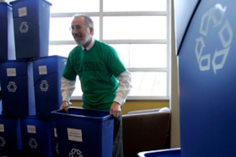 Donald J. Farish, president of Rowan University, hands out recycling bins. Rowan announcedit would move to single-stream recycling, which allows various recyclables to go in one bin.