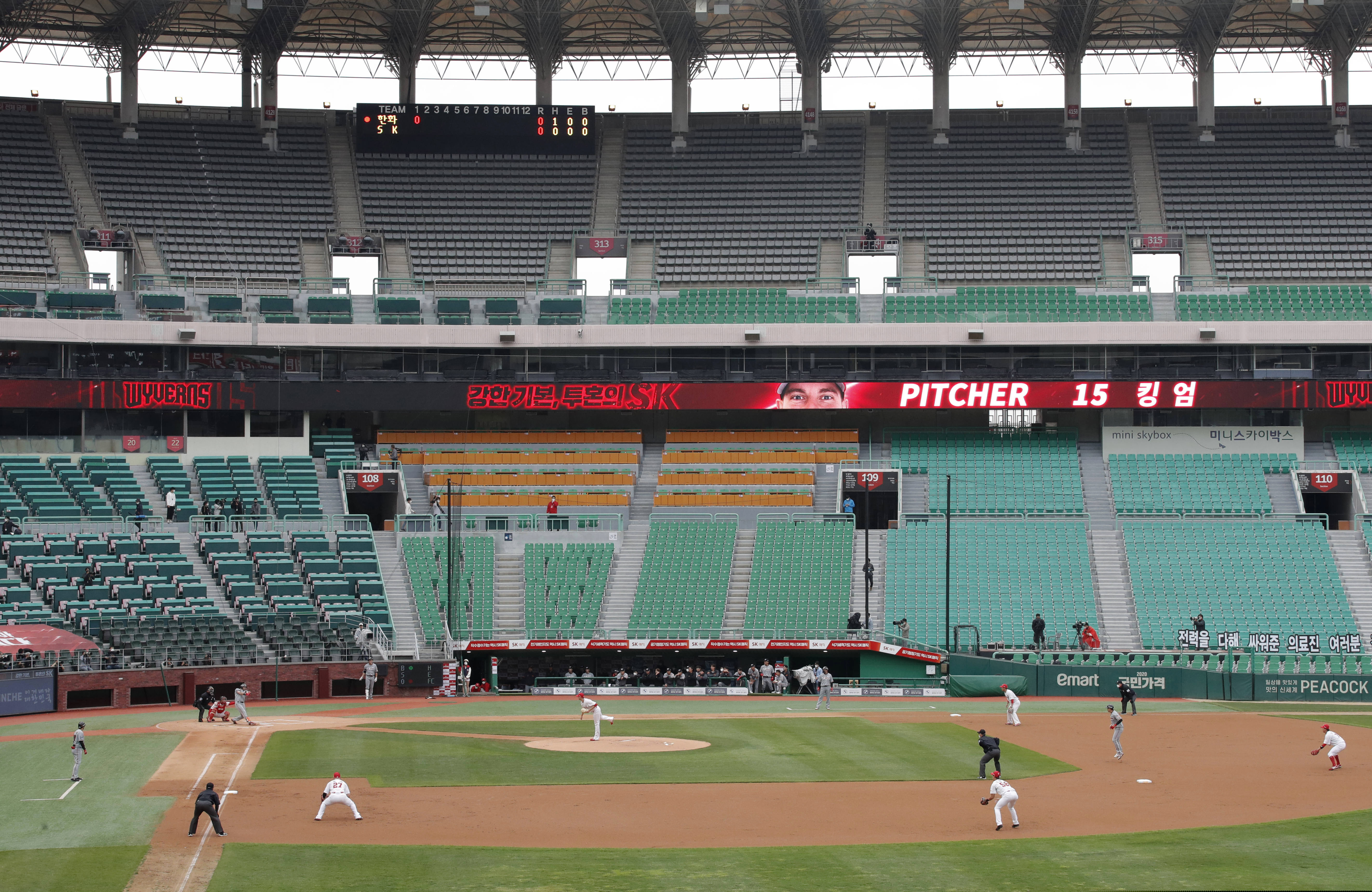 With umpires fitted with masks and cheerleaders dancing beneath vast rows of empty seats, a new baseball season got underway in South Korea following a weeks-long delay because of the coronavirus pandemic. (AP Photo/Lee Jin-man)