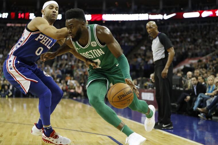 Boston Celtics guard-forward Jaylen Brown, right, drives past Philadelphia 76ers guard Jerryd Bayless during an NBA basketball game between the Boston Celtics and the Philadelphia 76ers at the O2 Arena in London, Thursday, Jan. 11, 2018.