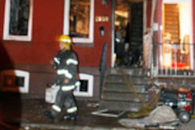 Firefighters examine the rowhouse at 1904 Carpenter St., where the child was found. The blaze was reported about 8 p.m. yesterday. Authorities are investigating whether the girl was home alone.