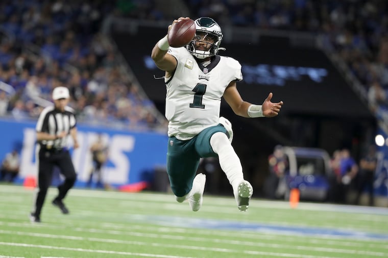 Philadelphia Eagles quarterback Jalen Hurts (1) leaps into the air like he is going to throw a pass, he keeps the ball and runs it into the red zone setting up the Eagles for a touchdown in the second quarter Sunday, October 31, 2021 at Ford Field in Detroit, Michigan.
