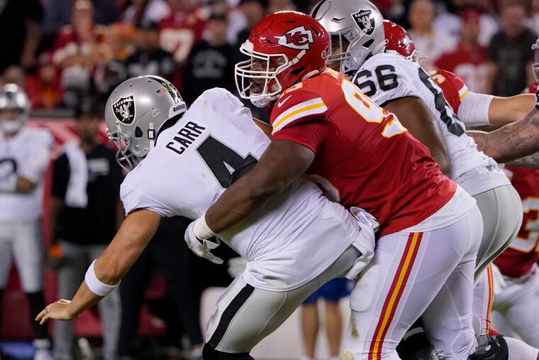 Raiders quarterback Derek Carr (4) is hit by Chiefs defensive tackle Chris Jones Monday night. Jones was called for roughing the passer on the play.