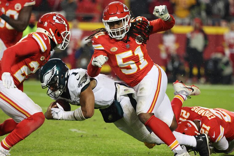 Eagles quarterback Jalen Hurts gets stopped by Kansas City Chiefs defensive end Mike Danna (center) and safety Mike Edwards (right) in the fourth quarter at GEHA Field at Arrowhead Stadium in Kansas City, Mo., on Monday, Nov. 20, 2023.