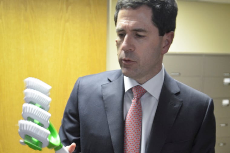 Robert Hill holds a Grout Gator, which he and one of his brothers invented. (Ron Tarver / Staff Photographer)