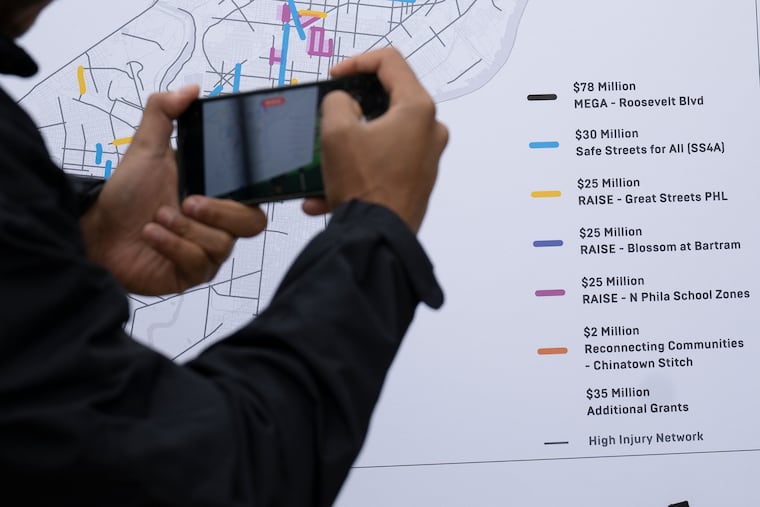 A man takes a photo of Vision Zero annual traffic reports statistics on Tuesday, Oct. 10. 2023, during a press conference on projects to make streets safer are on tap for Philadelphia neighborhoods this year