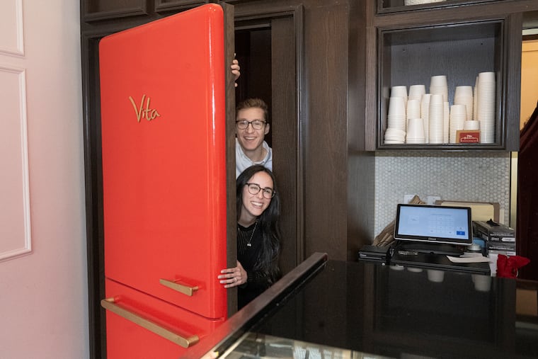 Massimo and Ana Boni at the refrigerator door that is the entrance of their Italian restaurant behind Vita, their gelato shop.
