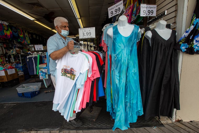 Raza Kahn, owner of Boardwalks Gifts and Souvenir store on the Atlantic City Boardwalk, fixes racks of merchandise as he opens Monday morning May 24, 2021. Businesses at the shore are gearing up for the Memorial Day weekend.