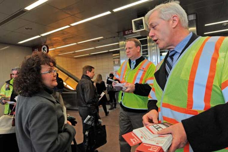 DRPA acting CEO John Hanson, PATCO general manager John Rink and DRPA Director of Transit Services Pat McBride meet commuters and hand out brochures informing riders of the new schedule at the Lindenwold PATCO station on Jan. 31, 2014. Here, Joanne Kupiec of Stratford complains to Hanson that her train was late yesterday. Rink is in the middle of the photo. ( APRIL SAUL / Staff )