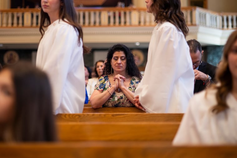 Jana Muhammad kneels after being confirmed at St. Monica Roman Catholic Church in Philadelphia on Saturday, April 18, 2026.