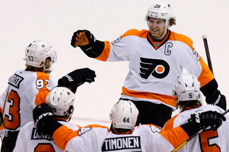 Claude Giroux (28) smiles as he arrives to join the celebration of a goal by Jakub Voracek (93), of the Czech Republic, against the Phoenix Coyotes, with teammates Braydon Coburn (5), Kimmo Timonen (44), of Finland, and Steve Downie (9) during the third period of an NHL hockey game Saturday, Jan. 4, 2014, in Glendale, Ariz. The Flyers defeated the Coyotes 5-3. (Ross D. Franklin/AP)
