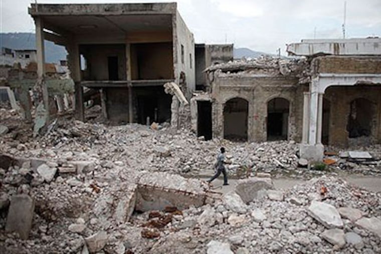 A man walks past buildings destroyed in an earthquake that hit Haiti six months ago. (AP Photo / Alexandre Meneghini)