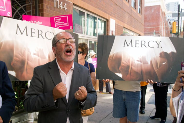 The Rev. Patrick Mahoney, director of the Christian Defense Coalition and national director of Philly Alive, prays outside Planned Parenthood on Locust Street. (CHARLES FOX/Staff Photographer)