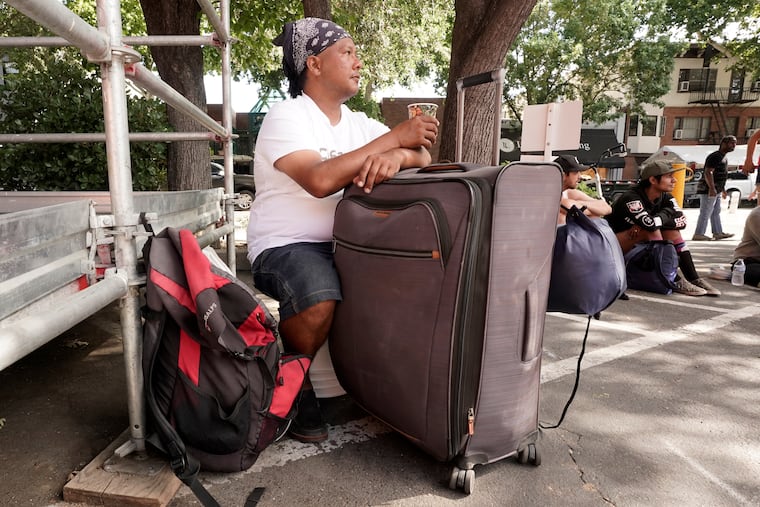Eric Santos uses a suitcase that he keeps all of his possessions in as a table while having a cup of coffee at ShowUp Sac, a nonprofit that provides food, clothing and showers to people experiencing homelessness in Sacramento, Calif., Tuesday, Aug. 9, 2022. Santos, who was recently evicted from his apartment and now sleeps on a park bench, frequents Show Up Sac, for meals and other assistance. Sacramento County had more than 9,200 people experiencing homelessness during this year's annual count, conducted in February.