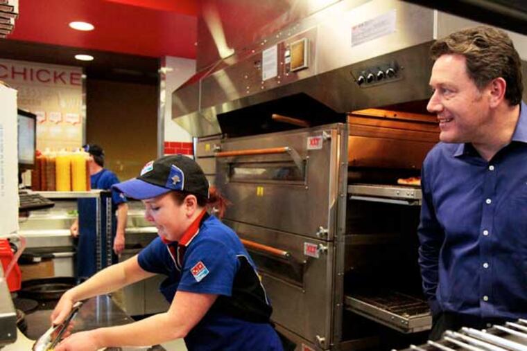 Domino's Pizza CEO Patrick Doyle keeps a close eye on Katie Ritchie makes a sandwich at the company's new design store in Seattle, Washington. The pizza chain is trying to expand it's food line up, such as overhauling it's salads, and upping it's customer interaction offering more carry out specials over delivery options. (Mark Harrison / Seattle Times / MCT)
