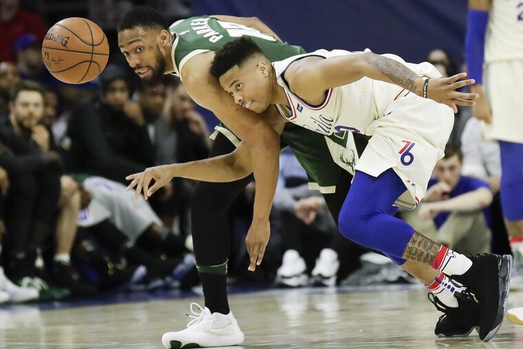 Sixers guard Markelle Fultz battles for a loose ball against Bucks forward Jabari Parker (left) during the second quarter.
