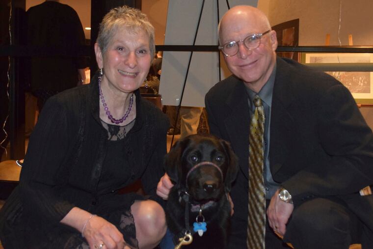 Puppy raisers Linda and Michael Dzuba with their dog-in-training Snugles at Canine Partners for Life's Art of the Bark fund-raising event at the Brandywine River Museum. MAGGIE HENRY CORCORAN
