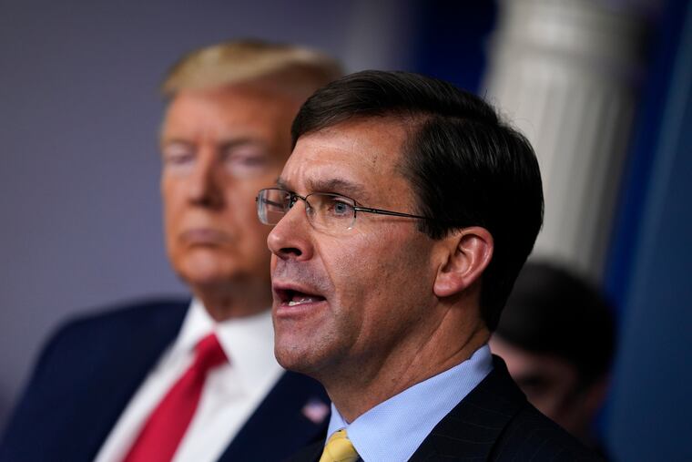 This March 18 photo shows Defense Secretary Mark Esper speaking as President Trump listens during a press briefing.