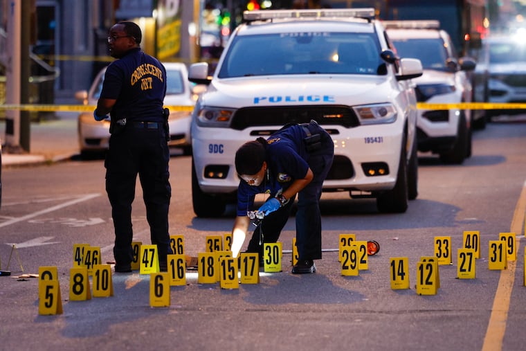 Crime scene investigators at the scene of a fatal shooting of a man on a bicycle at Snyder Ave and15th St. in South Philadelphia on Wednesday. About 40 shots were fired, according to police.