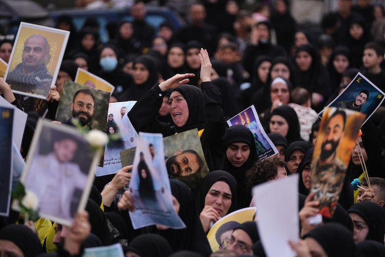 A woman mourns as other hold portraits of Hezbollah fighters, who were killed before the ceasefire in the war between Hezbollah and Israel, during a mass funeral procession Tuesday in the southern village of Kfar Sir in Lebanon.