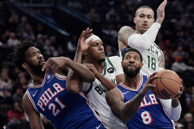 Sixers # 21 Joel Embiid battles Bucks # 3 Myles Turner as Bucks # 18 Kyle Kuzma pursues Sixers # 8 Paul George as he goes to the net in the first quarter of the Milwaukee Bucks vs. Philadelphia 76ers (Sixers) NBA game at Xfinity Mobile Arena in Philadelphia on Tuesday, Jan. 27, 2026.