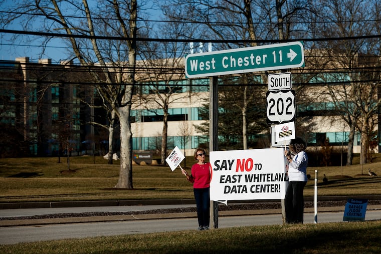 Kathy Weishaar (left) and Susan Bader, both of Malvern, protest in opposition of the expanded data center before the East Whiteland Planning Commission meeting held at Penn State Great Valley on March 9 in Malvern.