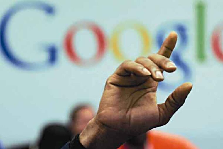 FILE - In this Oct. 17, 2012, file photo, a man raises his hand during at Google offices. Google's stock price topped $800 for the first time Tuesday, Feb. 20, 2013, amid renewed confidence in the company's ability to reap steadily higher profits from its dominance of Internet search and prominence in the increasingly important mobile device market. (AP Photo/Mark Lennihan)