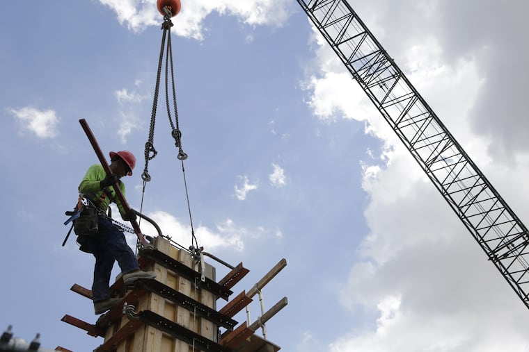 FILE- In this June 20, 2018 photo, a member of a construction team works on the site of Gables Station, a mixed use project featuring apartments, retail, a hotel and cafes, in Coral Gables, Fla. The U.S. economy grew by 4.1 percent in the April-June quarter. But experts warned it is not sustainable because the rate is based on temporary factor.