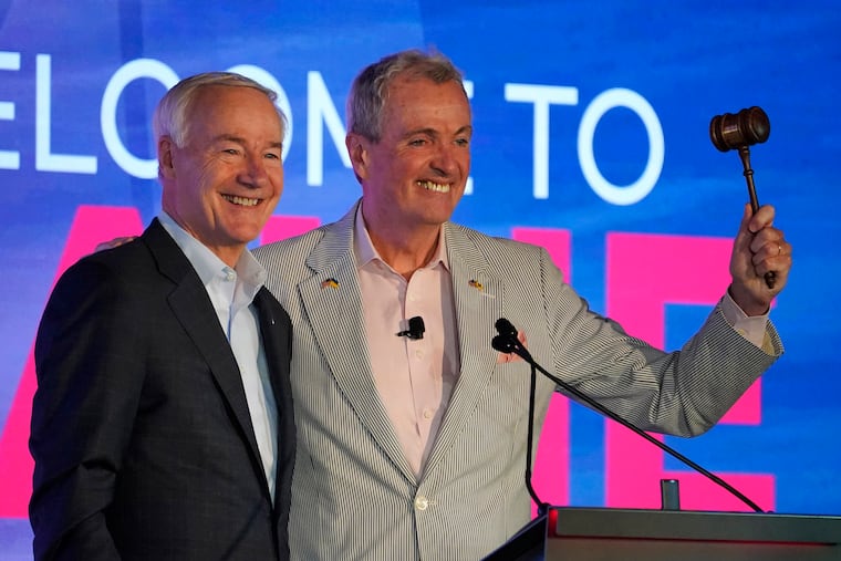 Arkansas Gov. Asa Hutchinson, left, and New Jersey Gov. Phil Murphy acknowledge applause at the National Governors Association summer meeting, Friday, July 15, 2022, in Portland, Maine.