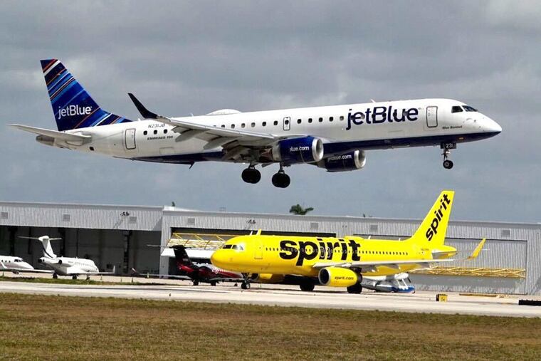 A JetBlue airliner lands past a Spirit Airlines jet on taxi way at Fort Lauderdale Hollywood International Airport on Monday, April 25, 2022. JetBlue Airways on Monday launched a second bid to buy Spirit Airlines, weeks after Spirit’s board of directors rejected the initial bid. (Joe Cavaretta/Sun Sentinel/TNS)