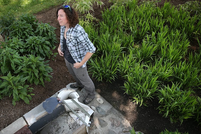 Villanova University graduate student Cara Albright stands next to a measuring station at a storm water management site near 39th Street and Girard Avenue in Philadelphia.