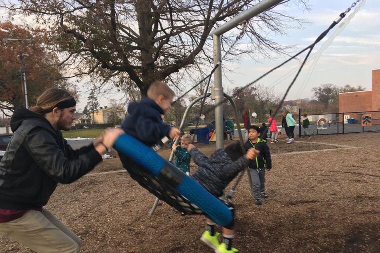 Bobby Grabowski, a Haddonfield Child Care staff member, pushes pupils on a swing at the playground at Central Elementary.