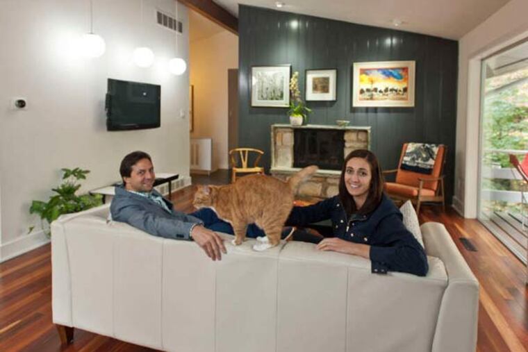 The dining room. A shelf wall adorned by colorful bowls separates the space from the kitchen.
