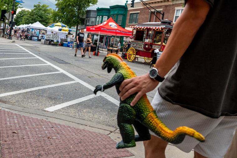 EJ Lim carries a vintage Godzilla action figure he purchased at the arts festival. He was visiting with Mary Winkler, whose mother was a vendor; the couple are from Merchantville.