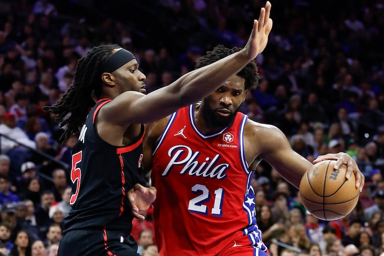 Sixers center Joel Embiid is guarded by Toronto Raptors forward Precious Achiuwa on Dec. 22.