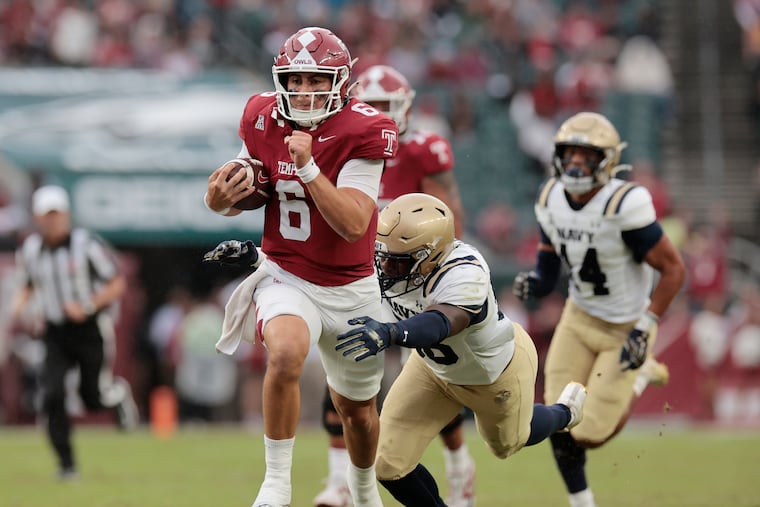 Temple quarterback Evan Simon finishes a big run before being pulled down by Navy’s MarcAnthony Parker.