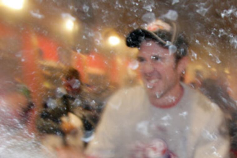 Chase Utley sprays champagne throughout the locker room.