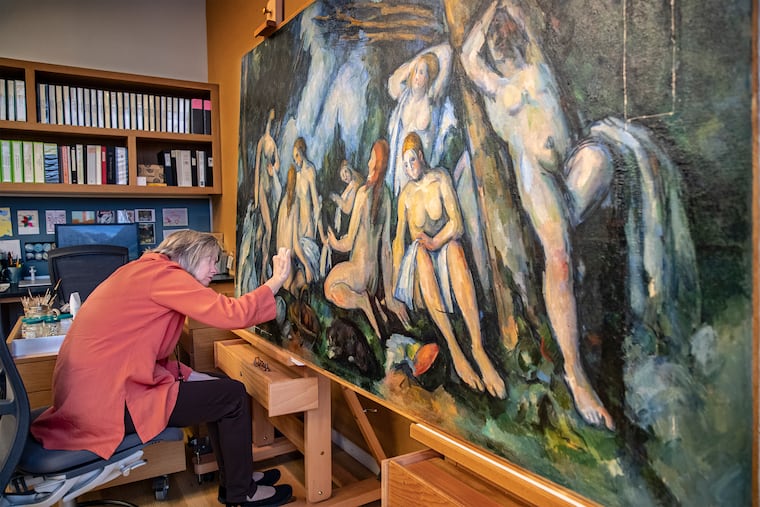Barbara Buckley, director of conservation and chief conservator of paintings at the Barnes Foundation, removes varnish from Paul Cezanne's The Large Bathers.