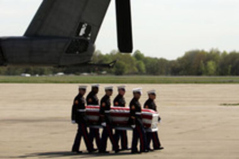 The flag-draped silver casket bearing Travis Manion's remains is borne from a military helicopter at Willow Grove Naval Air Station by a Marine honor guard.