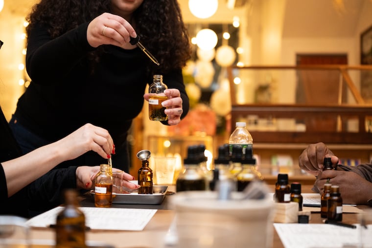 Linear Beauty founder Tasha Gear helps attendees mix oils and scents at a DIY body oil workshop at Moon and Arrow, a boutique in Queen Village.
