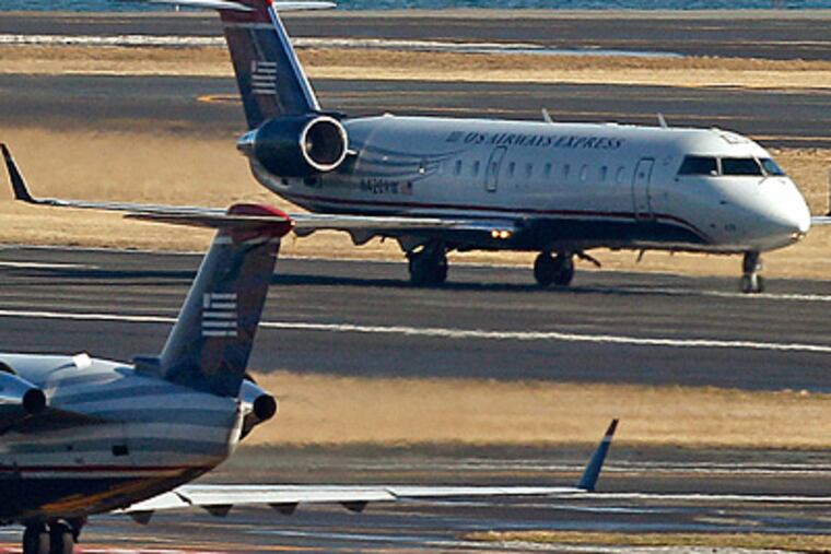 US Airways planes on taxiways at Boston's Logan Airport. "We're busy on every end," a travel agent said. (Charles Krupa / Associated Press)