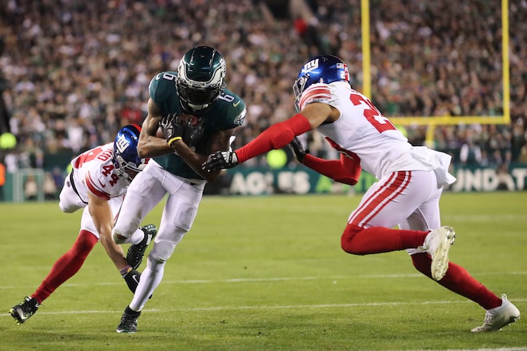 Philadelphia Eagles wide receiver DeVonta Smith reception and runs it in for a touchdown in the first quarter against New York Giants defenders at Lincoln Financial Field on Saturday, Jan. 21, 2023, in Philadelphia.