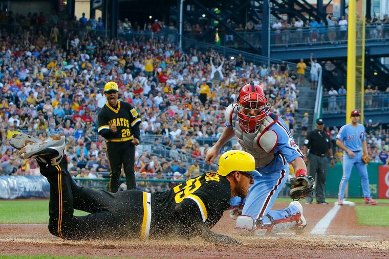 Joe Musgrove #59 of the Pittsburgh Pirates scores on a RBI single in the third inning against J.T. Realmuto #10 of the Philadelphia Phillies at PNC Park on July 20, 2019 in Pittsburgh, Pa. The Pirates won, 5-1. (Justin K. Aller/Getty Images/TNS)