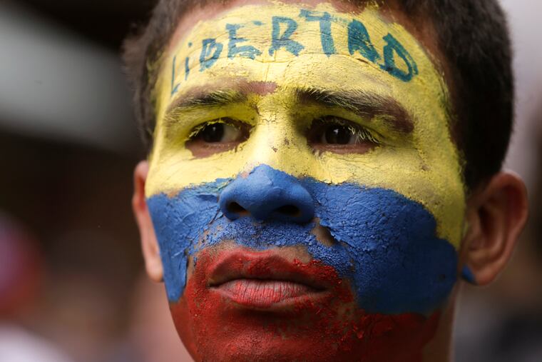 An opponent to Venezuela's President Nicolas Maduro, his face the colors of the Venezuelan national flag and the Spanish word for "Freedom" written on his forehead, takes part in a march in Caracas, Venezuela, Saturday, May 4, 2019. Opposition leader Juan Guaido took his quest to win over Venezuela's troops back to the streets, calling his supporters to participate in an outreach to soldiers outside military installations across the country.
